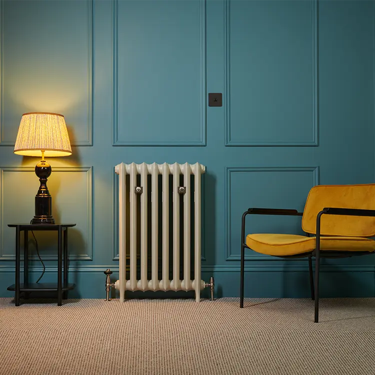 Cream cast iron column radiator in a teal panelled living room