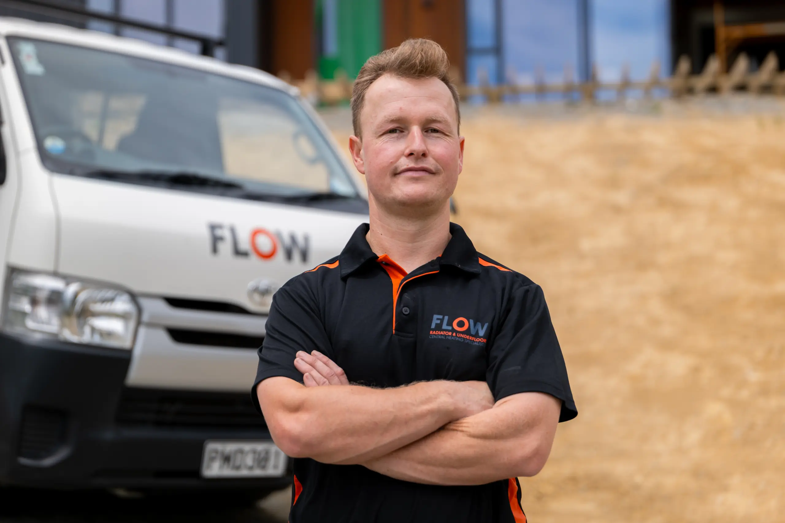 Flow Heating team member standing beside a company van