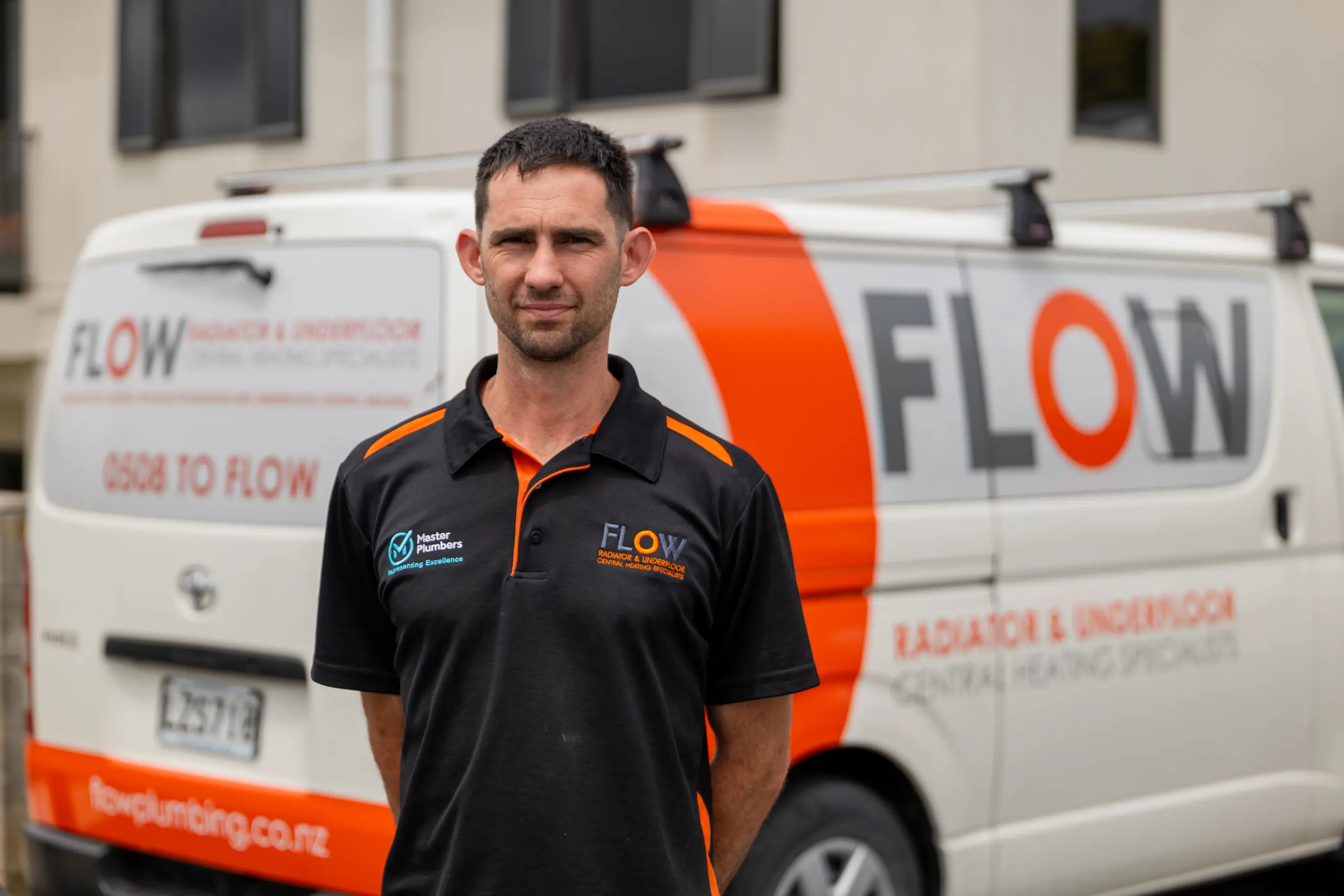 Flow Heating team member outside the workshop beside a company van