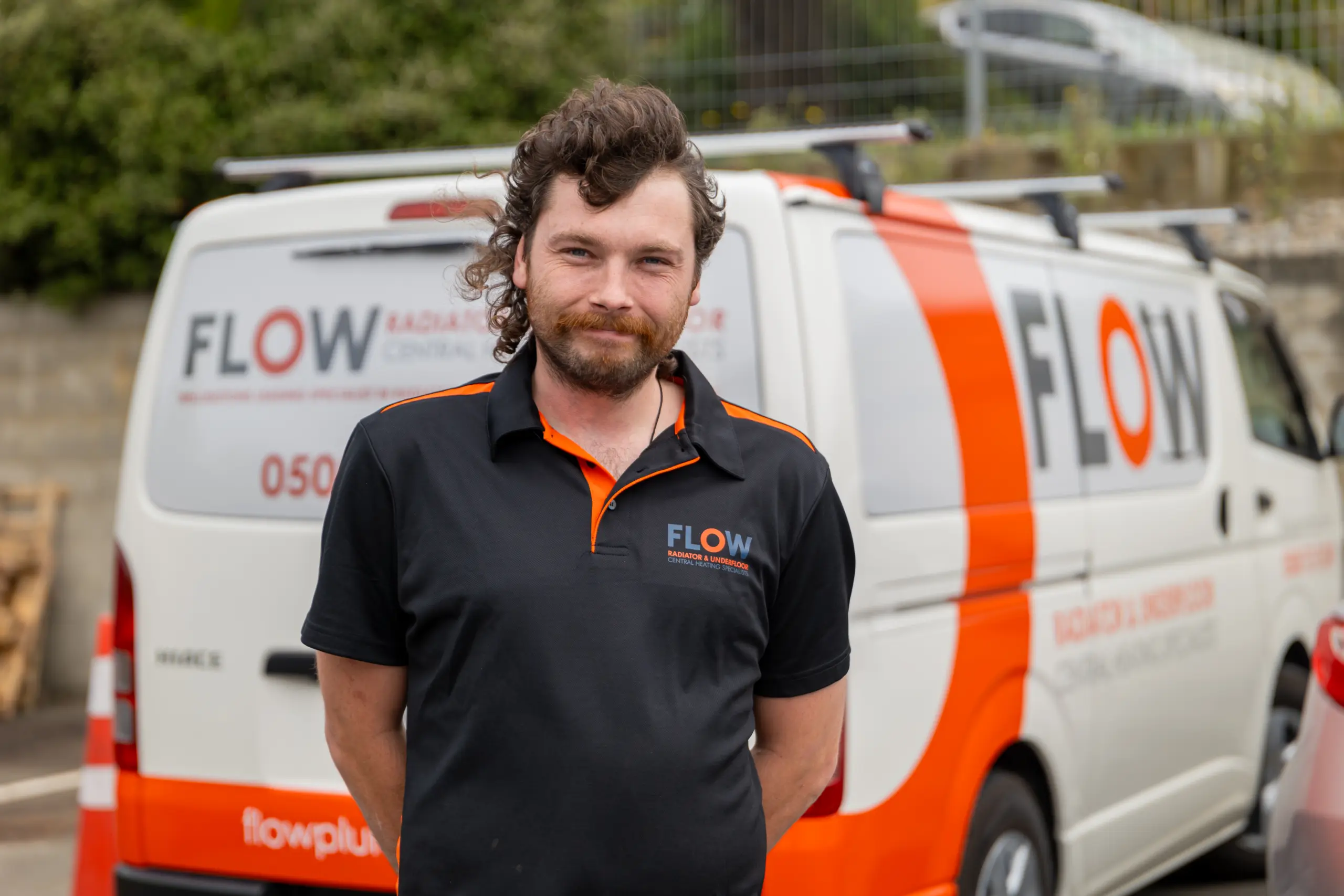 Flow Heating team member beside a Flow Heating van