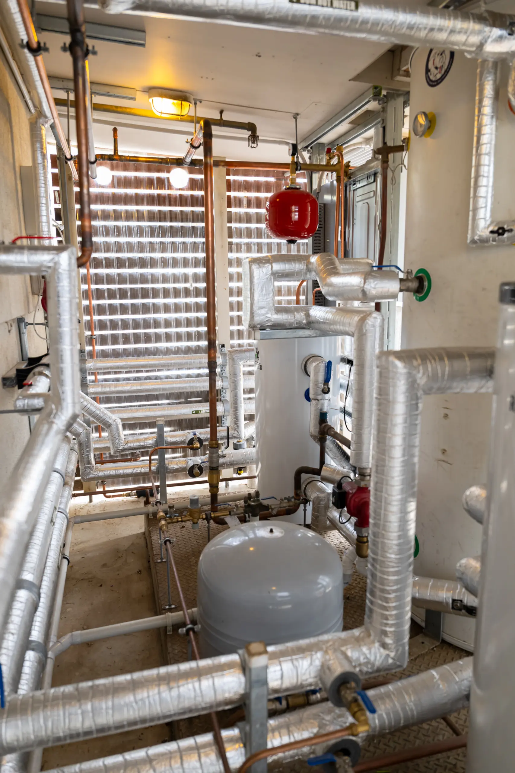 Insulated pipework and cylinder in a commercial plant room